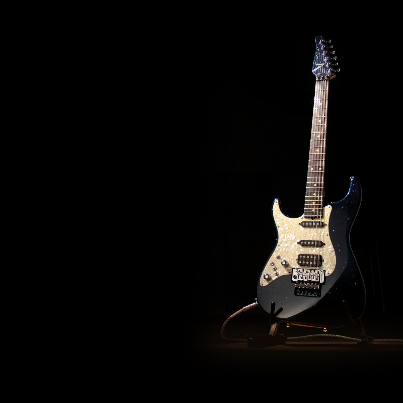 Guitarra parada en la sala, con luz en el piso